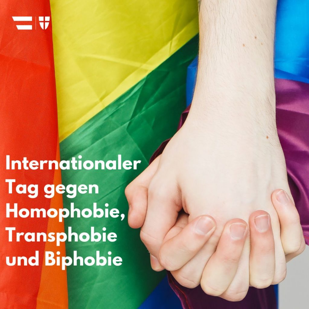 Titel: Internationaler Tag gegen Homophobie, Transphobie und Biphobie Bild: Hände halten einander vor Pride Flagge